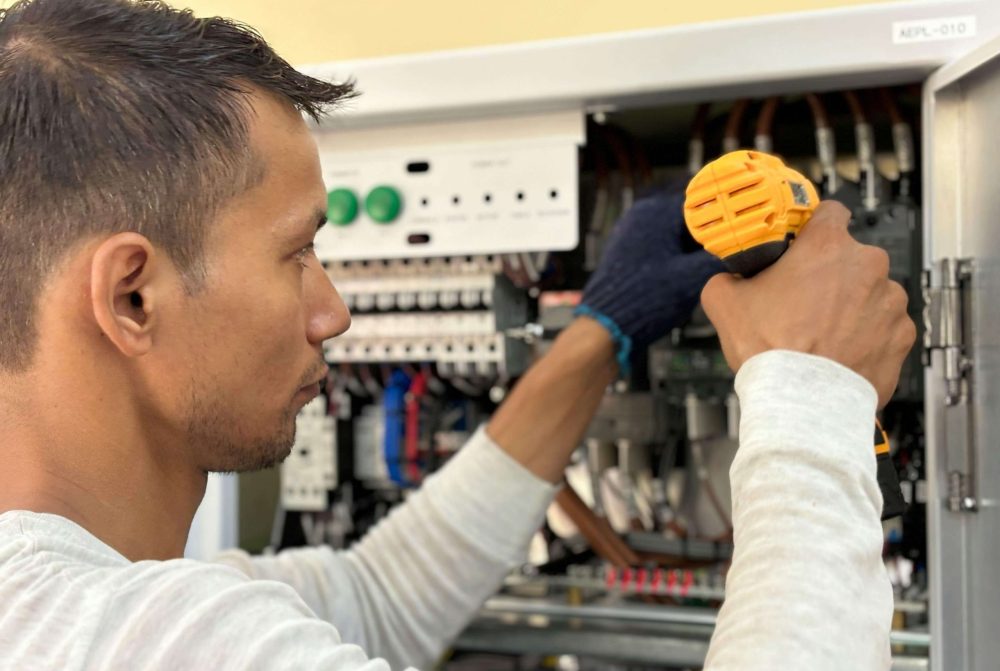 Electrical panel upgrades Gravity Electrical Calgary man fixing panel
