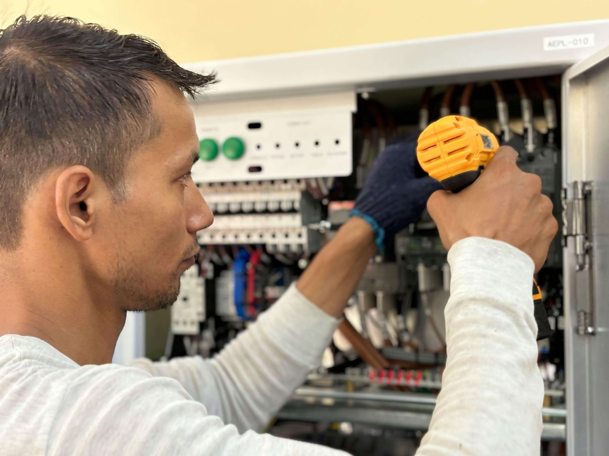 Electrical panel upgrades Gravity Electrical Calgary man fixing panel